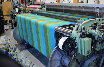 A modern weaving machine creating a colorful fabric